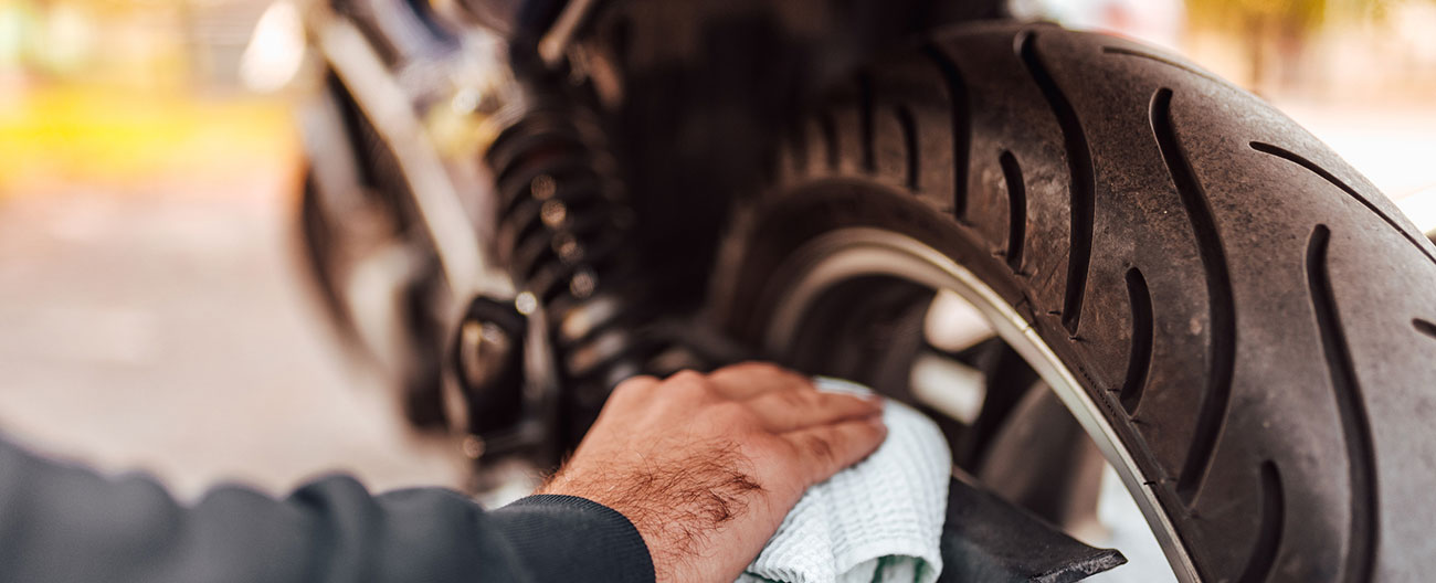 Man cleaning bike with rag